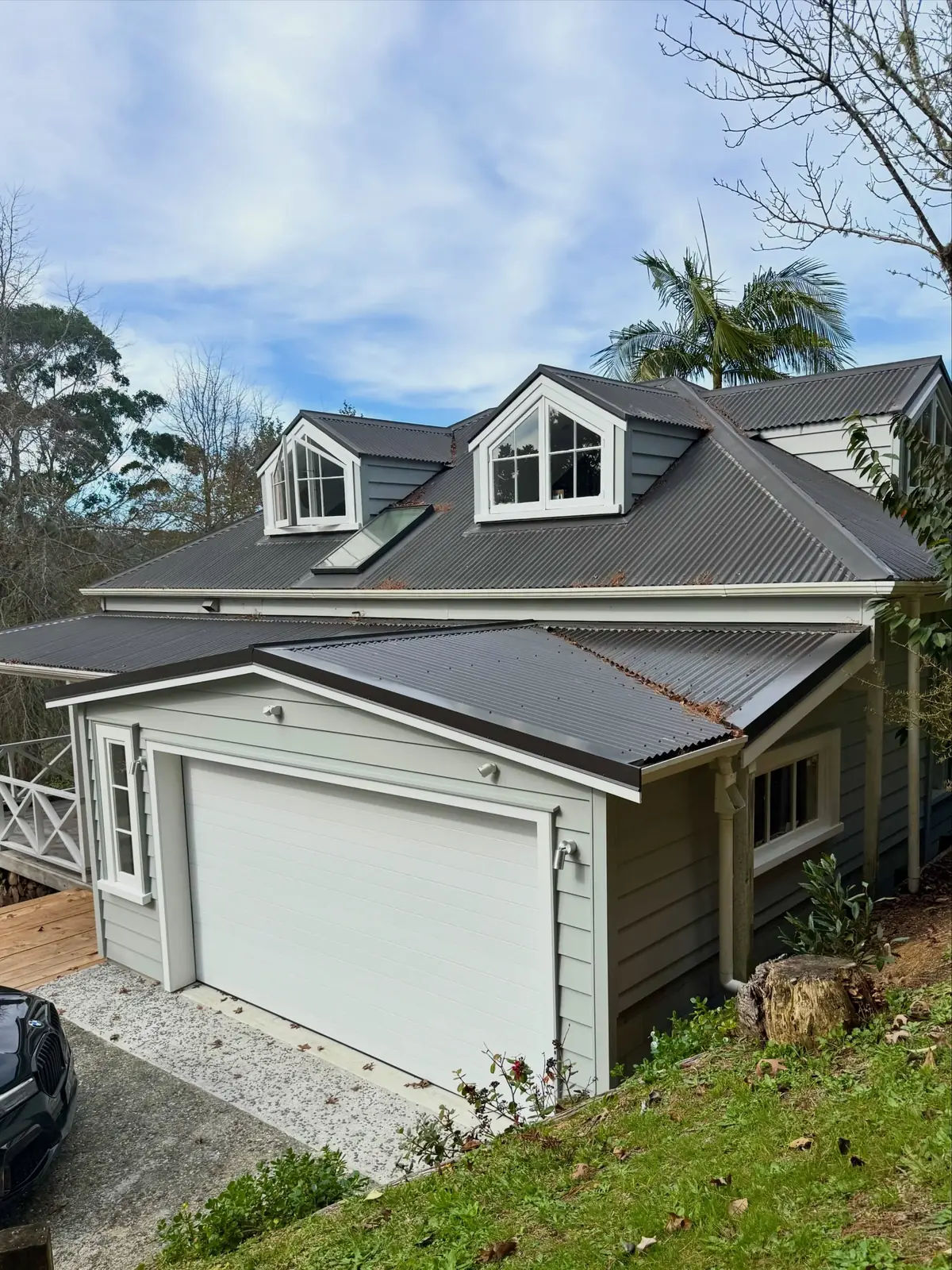 A renovated villa with matching dormer windows and a new garage