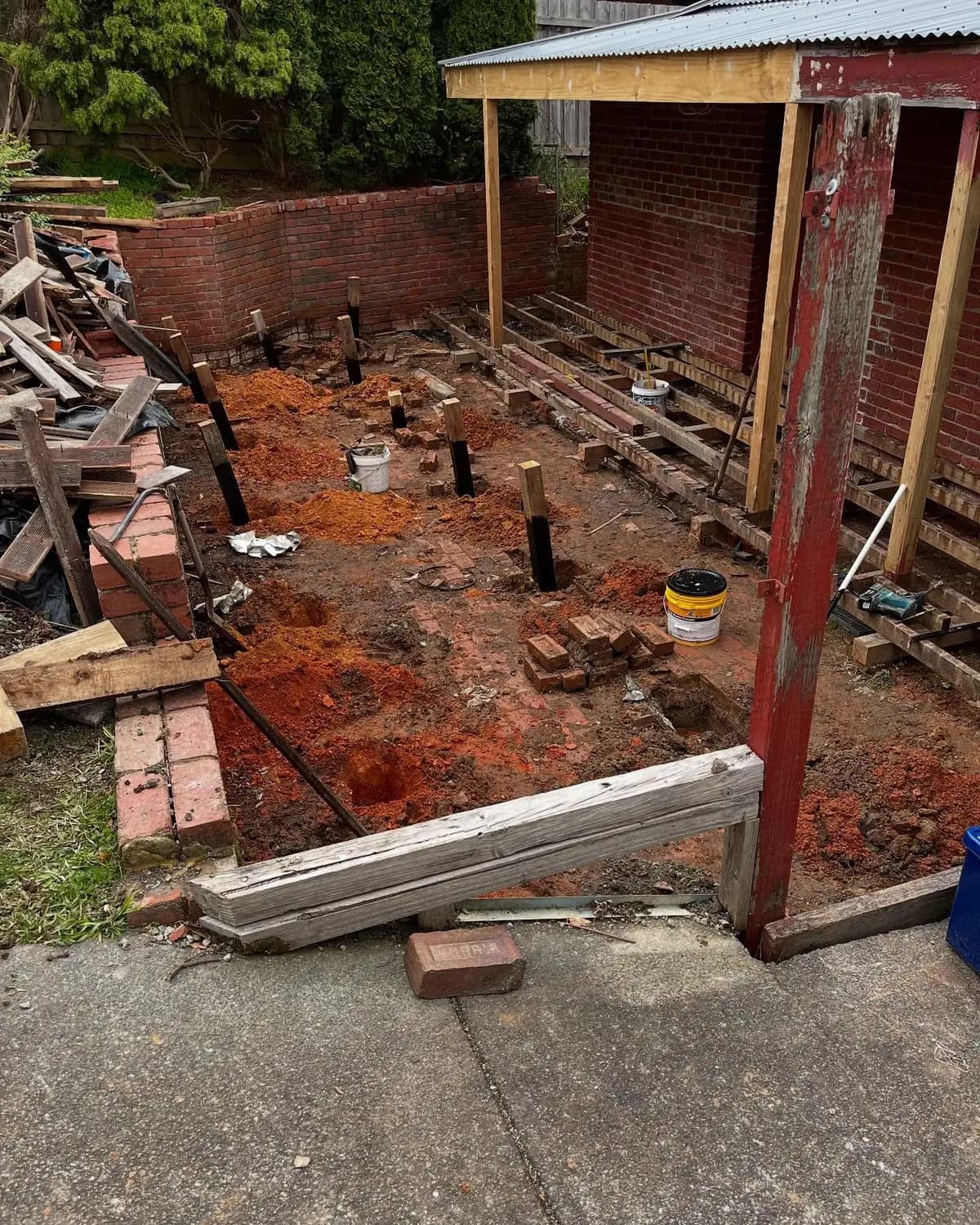 A backyard deck rebuild stripped back to its stumps and bearers
