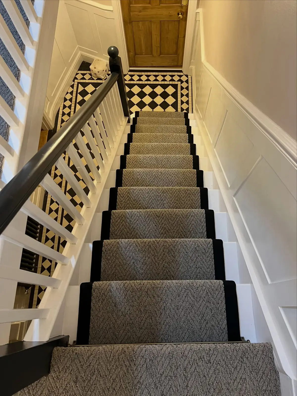 Herringbone stair runner with black binding, a Victorian tiled hallway floor at the top of the stairs