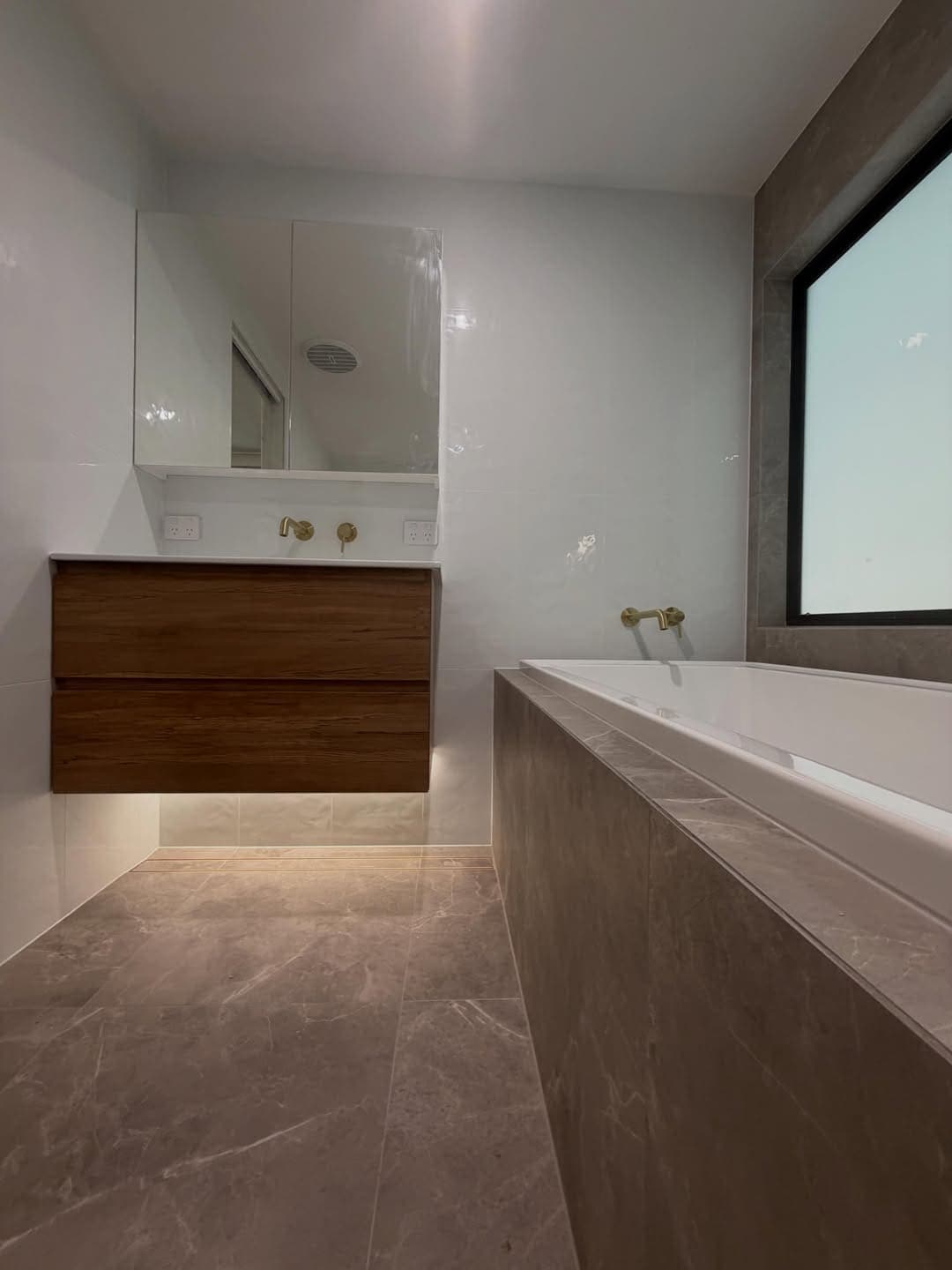 Timber vanity with brushed brass tapware