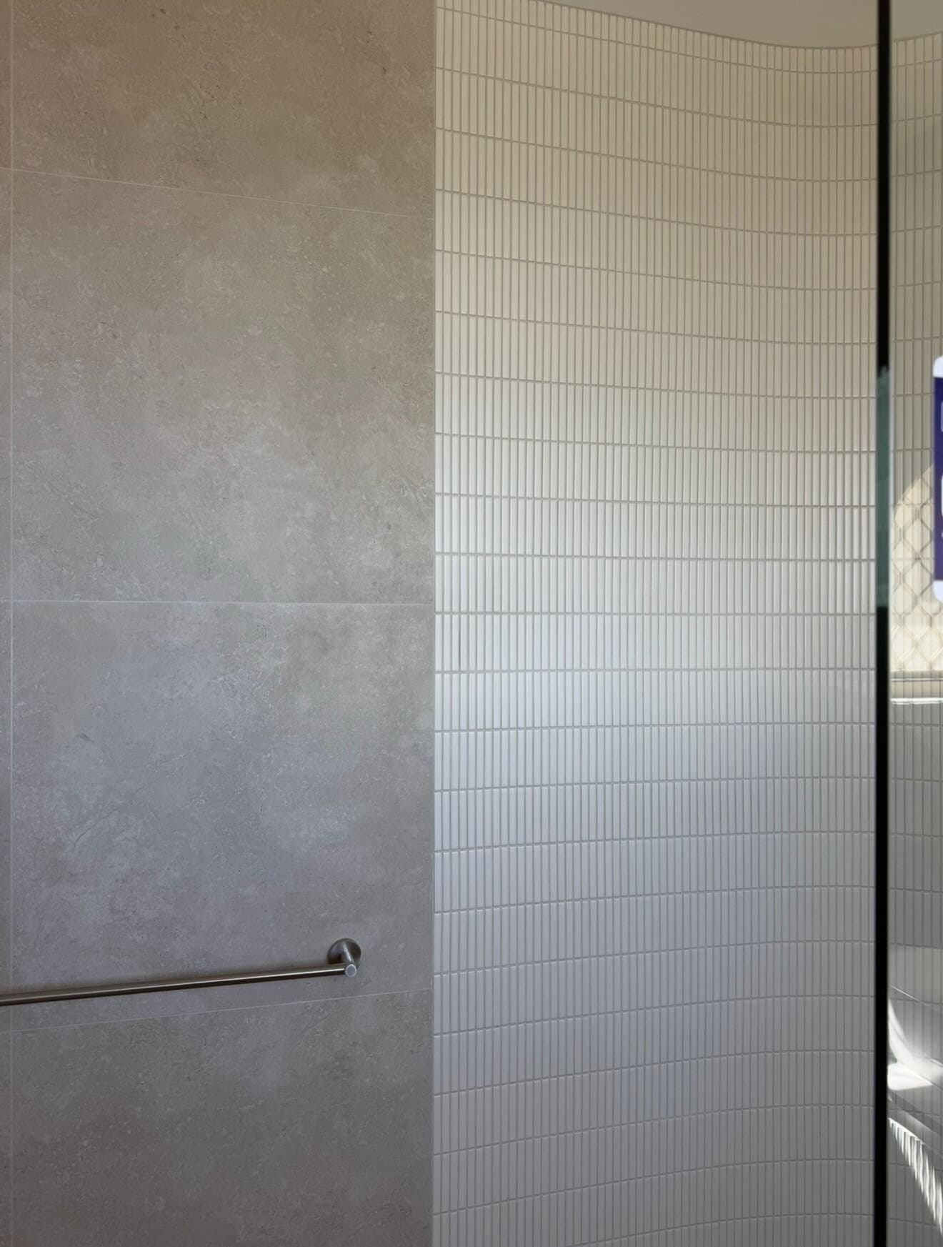 Close-up of finger-tile work on a curved shower wall
