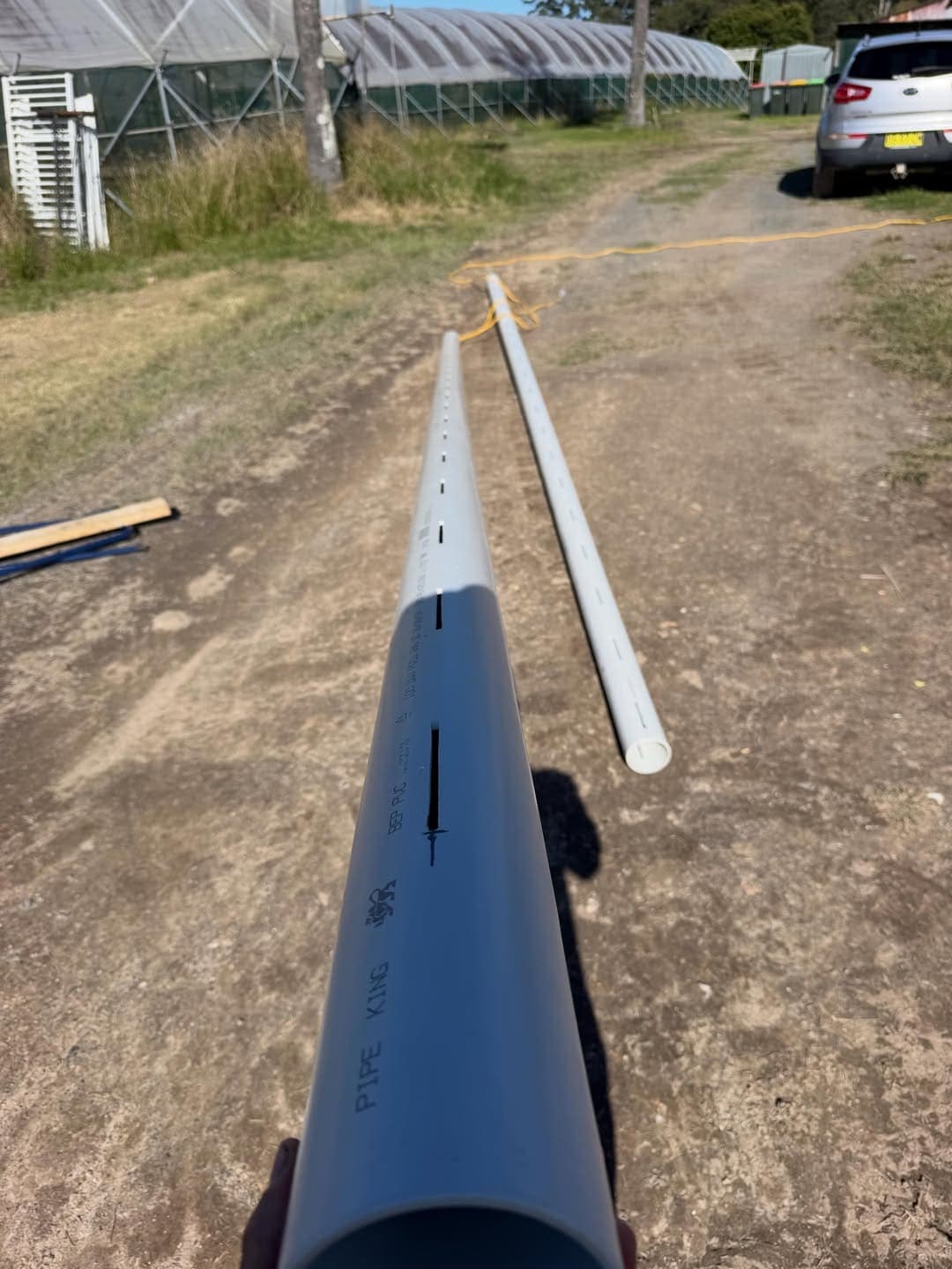 Blue PVC water line laid along a rural driveway