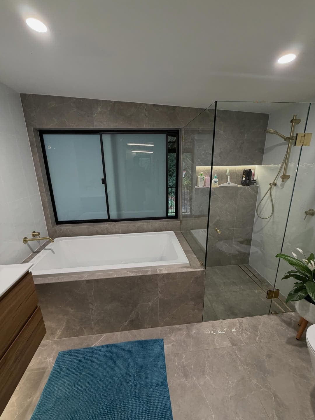 Bathroom with a tiled bath surround and walk-in shower